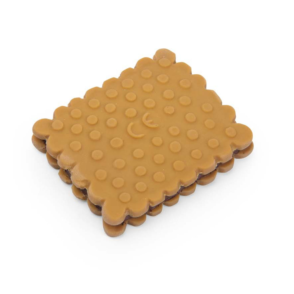 A rectangular, toy cookie made of rubber, mimicking a sandwich biscuit with scalloped edges and embossed with "Moulin Roty" on a white background.