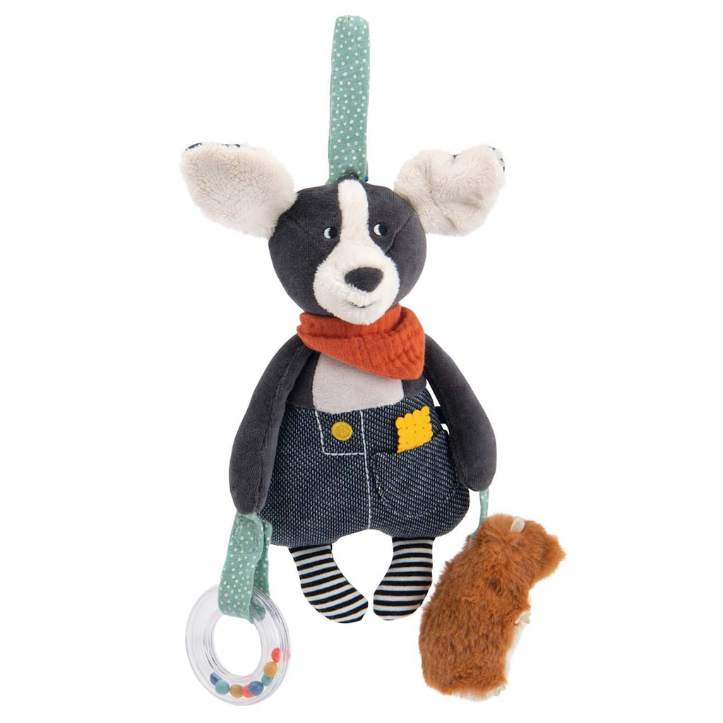 Plush dog toy with floppy ears, a red scarf, denim overalls, and striped legs, holding a clear ring with beads and a brown fuzzy accessory. Whimsical and playful.