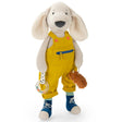 Plush dog toy wearing yellow overalls and blue shoes holding a rattle.