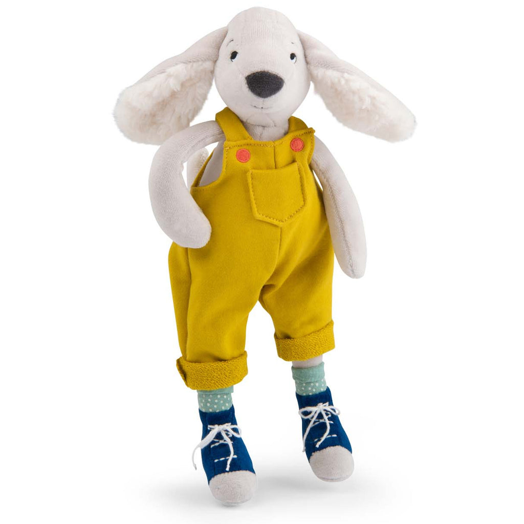 Plush toy of a dog in yellow overalls with pink buttons, polka dot socks, and blue shoes. It has floppy ears and a friendly expression.