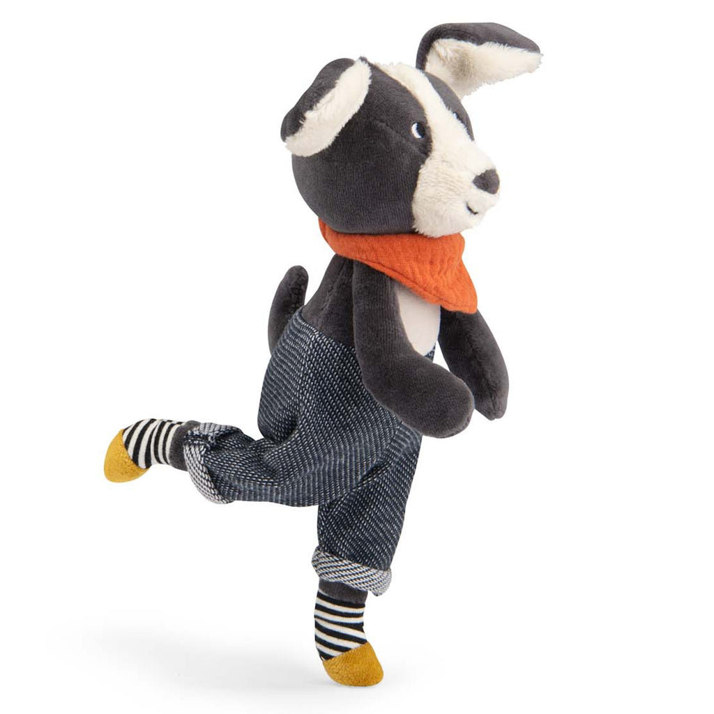 Plush dog toy with a cute expression wearing blue overalls, an orange scarf, and striped socks. The toy has floppy ears and a playful look.