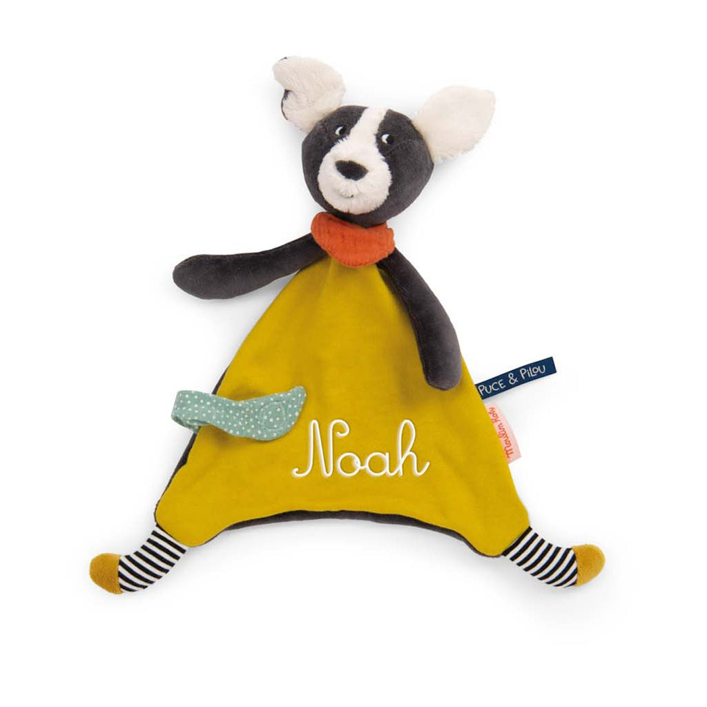 Soft toy dog with black head, white ears, and snout. It has a yellow triangular body, red neckerchief, striped legs, and a green polka-dot tail. Cheerful tone.