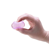 A hand squeezing a small, squishy purple ice cube fidget toy against a white background.