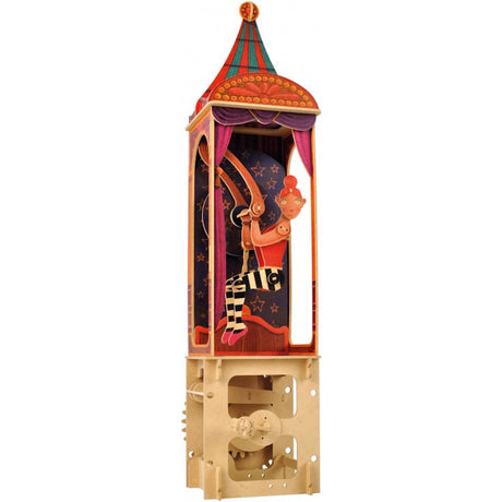 A colorful paper automaton of a circus performer with orange hair on a trapeze, encased in a vibrant, star-patterned tower. The base reveals gears.