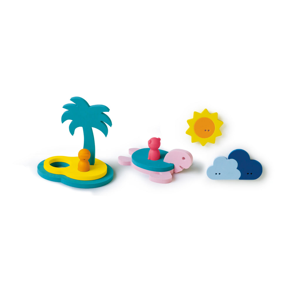 Colorful wooden toys depict an island with a palm tree, turtle with a pink rider, sun, and clouds, conveying a playful, beach-themed scene.