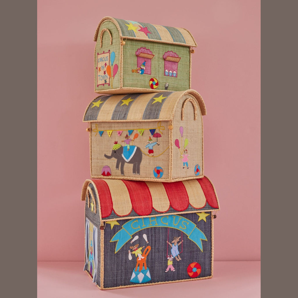 Stacked fabric storage boxes resembling a circus, each adorned with colorful illustrations of stars, balloons, an elephant, and circus performers on a pink backdrop.