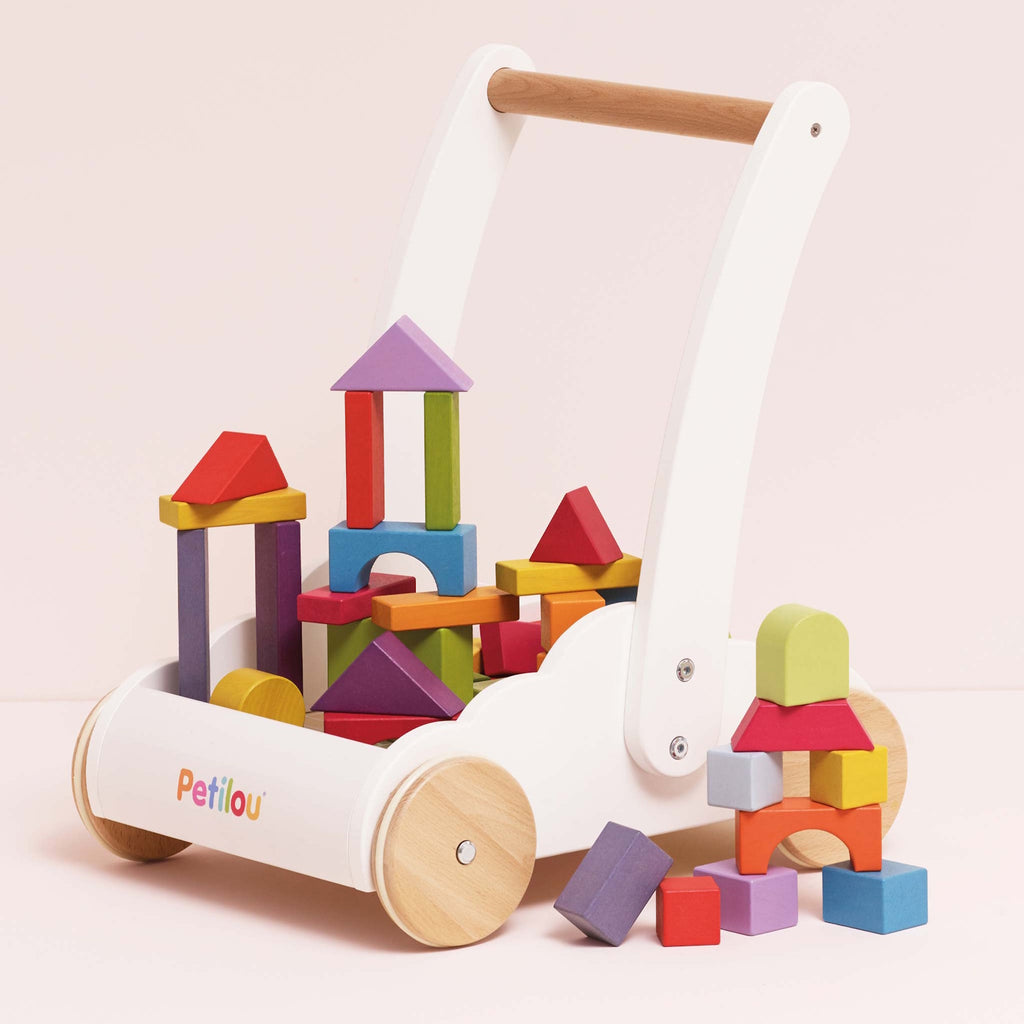 Wooden baby push walker with colorful blocks stacked in various shapes. Features a white frame, wooden handle, and wheels, evoking playful creativity.