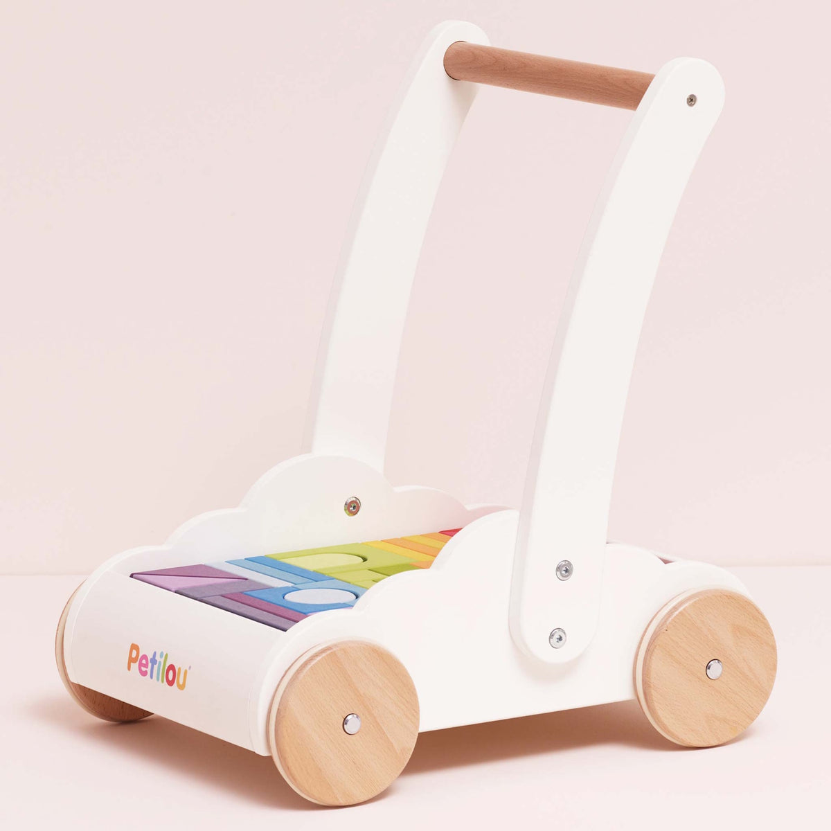 Wooden baby walker with a white frame, natural wood wheels, and rainbow-colored blocks. The design is playful and cute, set against a light pink background.