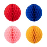 Four honeycomb paper balls in red, blue, pink, and yellow arranged in a grid against a white background.