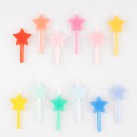 Twelve star-shaped birthday candles in pastel and rainbow colors laid out in two staggered rows.