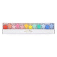 Boxed set of 12 Meri Meri star-shaped birthday candles arranged in a rainbow gradient.