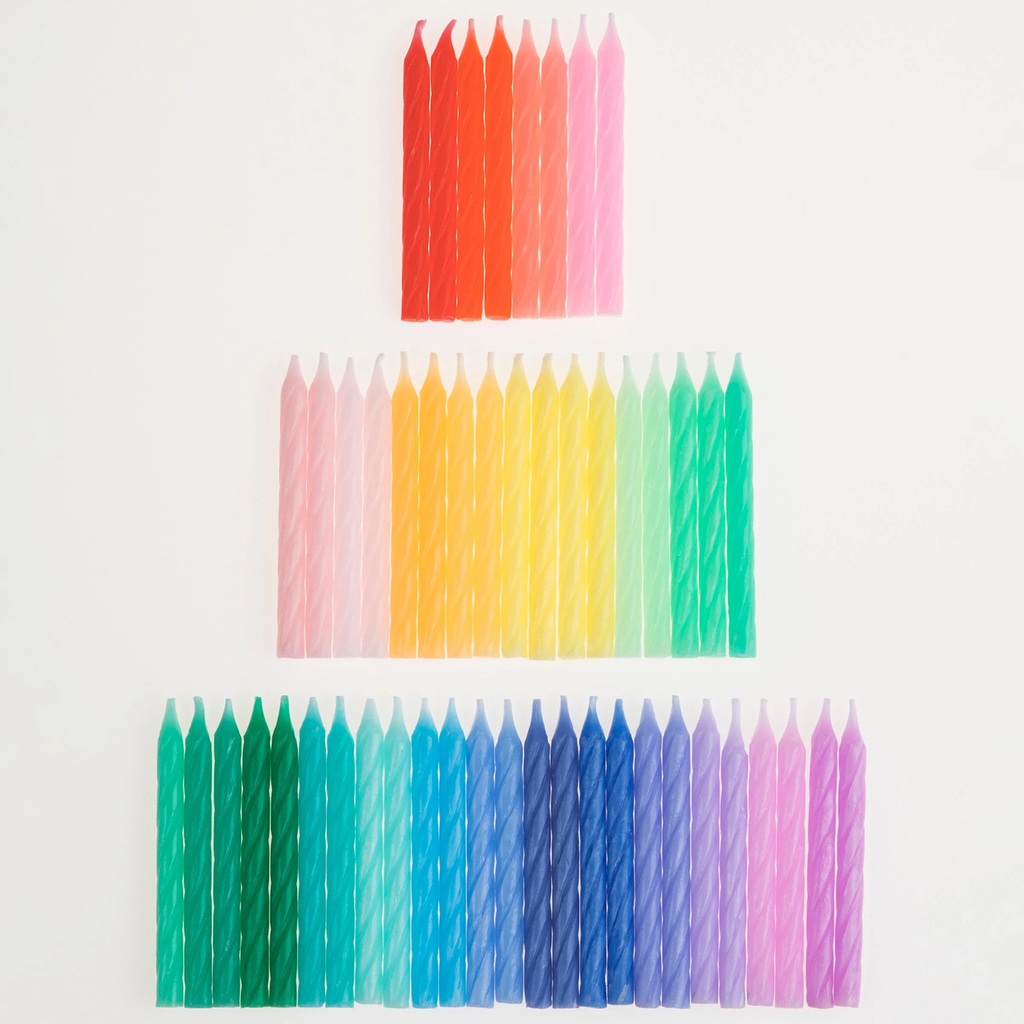 A set of colorful spiral candles in a rainbow palette, perfect for decorating cakes and celebrations.