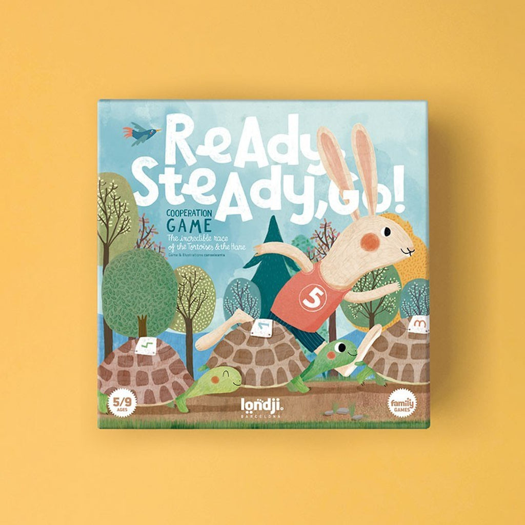 Children's board game cover: A cheerful hare in a red jersey with number 5 races over turtles in a forest. Text reads "Ready Steady Go!" and "Cooperation Game."