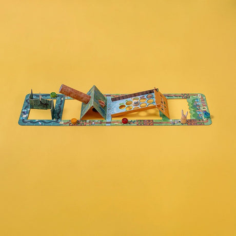 Board game on yellow background with a winding path, 3D elements like a house and holes labeled "Goal," colorful game pieces, and playful design.