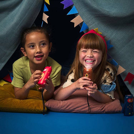 Two smiling young girls inside a play tent holding small, animal-shaped flashlights.