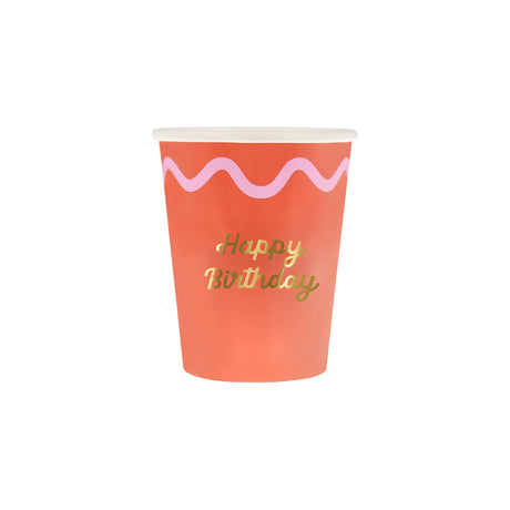 Red paper cup with a pink wavy line and gold script reading "Happy Birthday" on a white background.