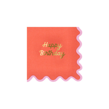 A red birthday napkin with a pink scalloped edge and gold foil text that reads "Happy Birthday."