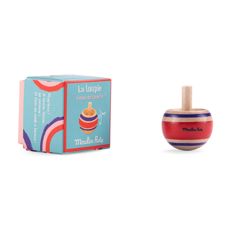 Moulin Roty red wooden spinning top toy with stripes next to its illustrated blue product packaging box.