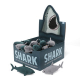 A display box of 24 shark-shaped erasers with various shades of gray and teal. The box features a shark illustration, conveying a playful theme.
