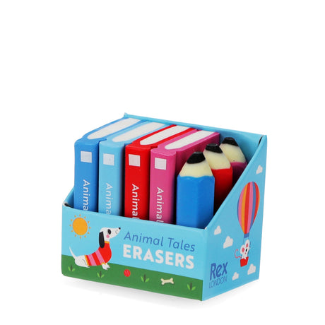 Colorful erasers are shaped like books and pencils in a decorative box labeled "Animal Tales Erasers." A cheerful illustration of a dog adorns the box.