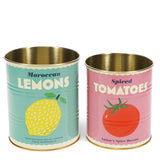 Two retro-style tin canisters with colorful labels: the left in teal for "Moroccan Lemons" with a lemon graphic, the right in pink for "Spiced Tomatoes" with a tomato graphic.