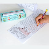 Child's hand using a multicolored pencil to complete a maze on a woodland-themed coloring sheet featuring a squirrel. A package labeled "Forest Friends Mini Colouring & Games" is nearby.
