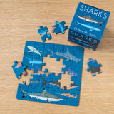 Rex London sharks 24-piece mini jigsaw puzzle with colorful illustrations and box on a wooden surface.