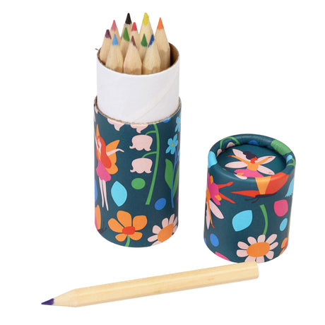 A colorful cylindrical box with vibrant floral and fairy patterns holds sharpened colored pencils. One pencil lies outside, creating a playful and creative vibe.