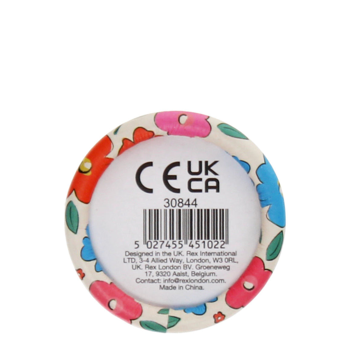 A round item with a floral pattern featuring red, blue, and pink flowers with green leaves surrounds a central label with product codes and UK/CA text.