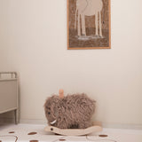 Plush mammoth rocking horse in a nursery room with an elephant framed picture on the wall.