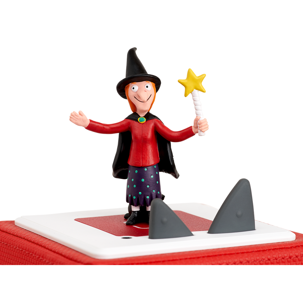 A cartoonish witch with a red top, polka-dotted skirt, and a black cape holds a star-tipped wand, smiling and gesturing.