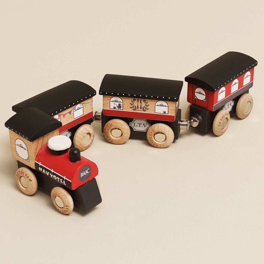 Wooden toy train with a red engine and three brown cars. Each car has detailed window decals and wooden wheels, evoking a playful, vintage charm.