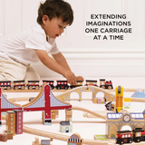 A child plays with a wooden train set featuring bridges and buildings, conveying a sense of creativity and exploration. Accompanied by the text, "Extending imaginations one carriage at a time."