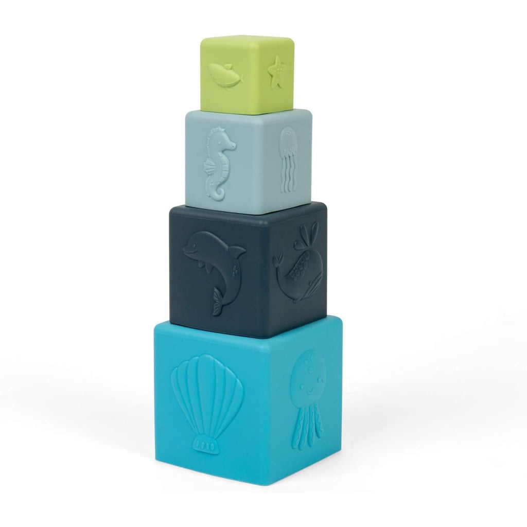 Four soft toy blocks stacked vertically, each embossed with sea creatures like a seahorse and dolphin. Colors range from light green to various blues.