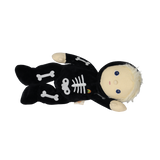 Plush blonde doll in a black skeleton suit lying down horizontally against a white background.