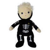 Plush blonde doll wearing a black skeleton bodysuit with embroidered bones and a rainbow patch.