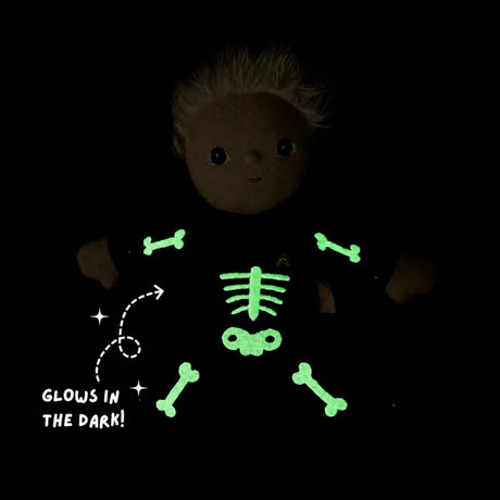 Plush doll in a skeleton costume with glowing green embroidered bones against a dark background.