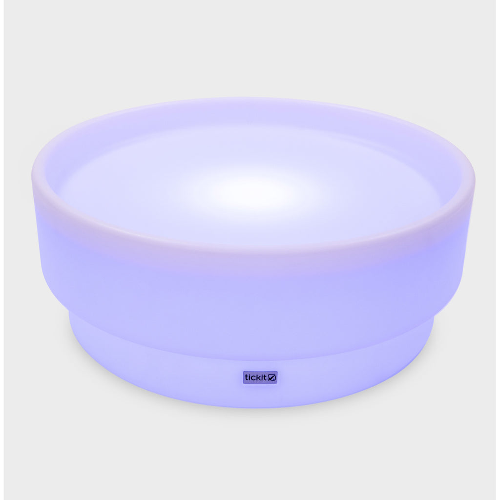 A softly glowing LED table with a shallow well, designed for sensory exploration, water play, and immersive learning experiences.