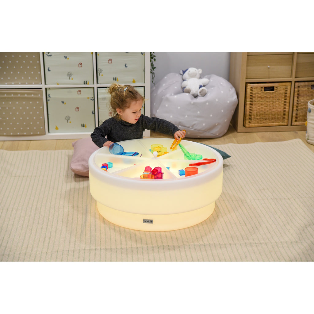 A softly glowing LED table with a shallow well, designed for sensory exploration, water play, and immersive learning experiences.