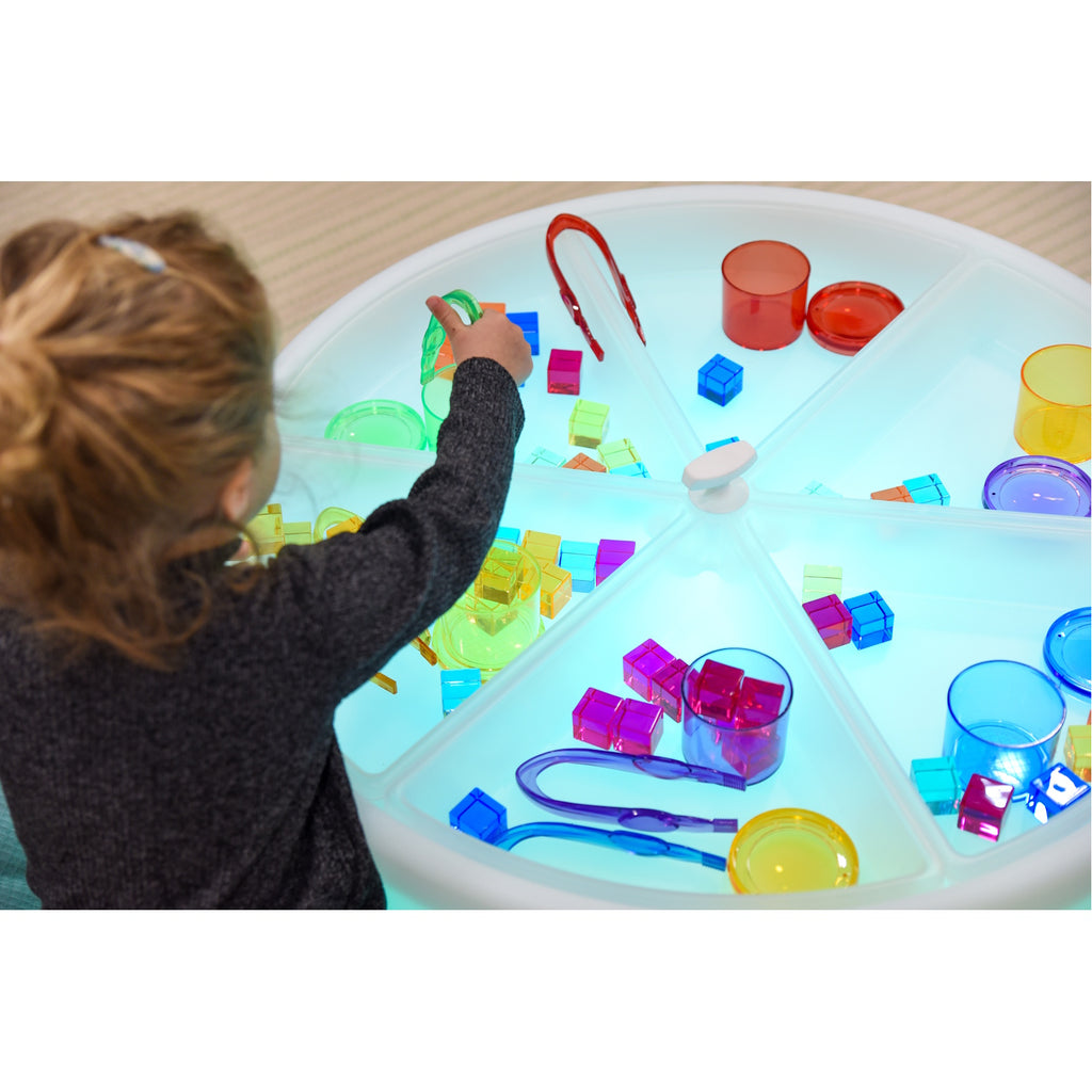 A softly glowing LED table with a shallow well, designed for sensory exploration, water play, and immersive learning experiences.