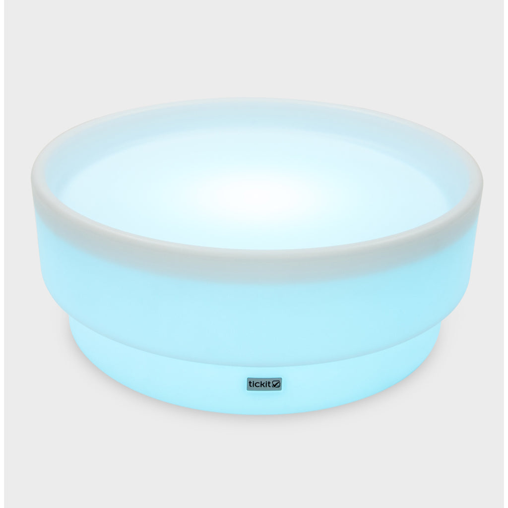 A softly glowing LED table with a shallow well, designed for sensory exploration, water play, and immersive learning experiences.