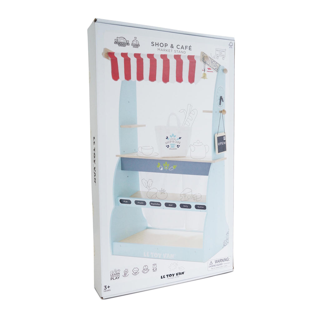 Box for Le Toy Van's "Shop & Café Market Stand" shows a toy store setup with a red-striped awning. Illustrated graphics suggest playful shopping.