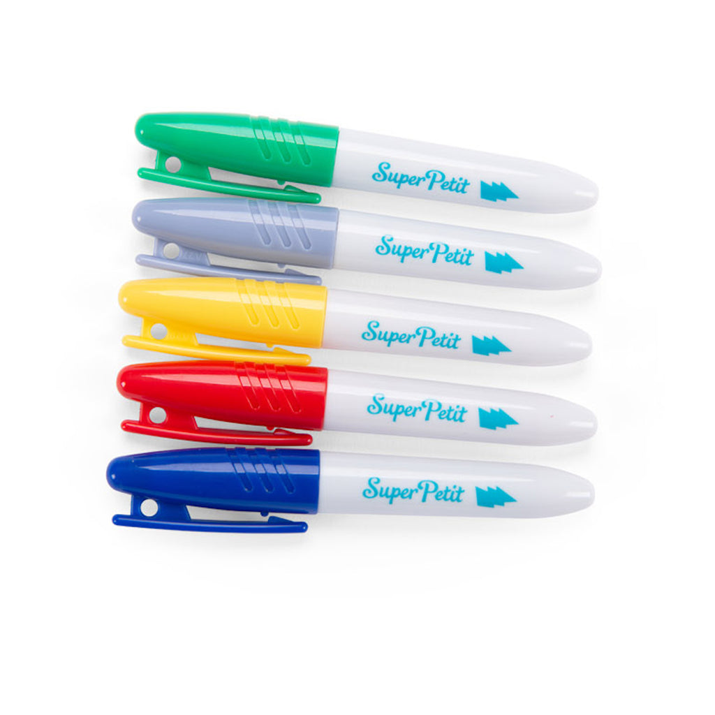 Five colorful markers arranged in a horizontal line. Caps are green, gray, yellow, red, and blue. Each marker has "SuperPetit" written on it.