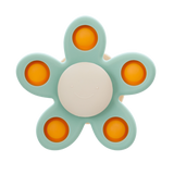 A soft silicone toy with a flower-shaped design, featuring gentle spinning motion in neutral colors, perfect for sensory play and motor skill development.