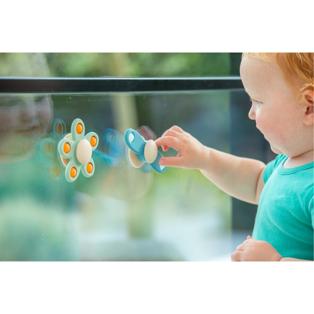 A soft silicone toy featuring a propeller design in neutral tones, ideal for sensory exploration and fine motor skill development.