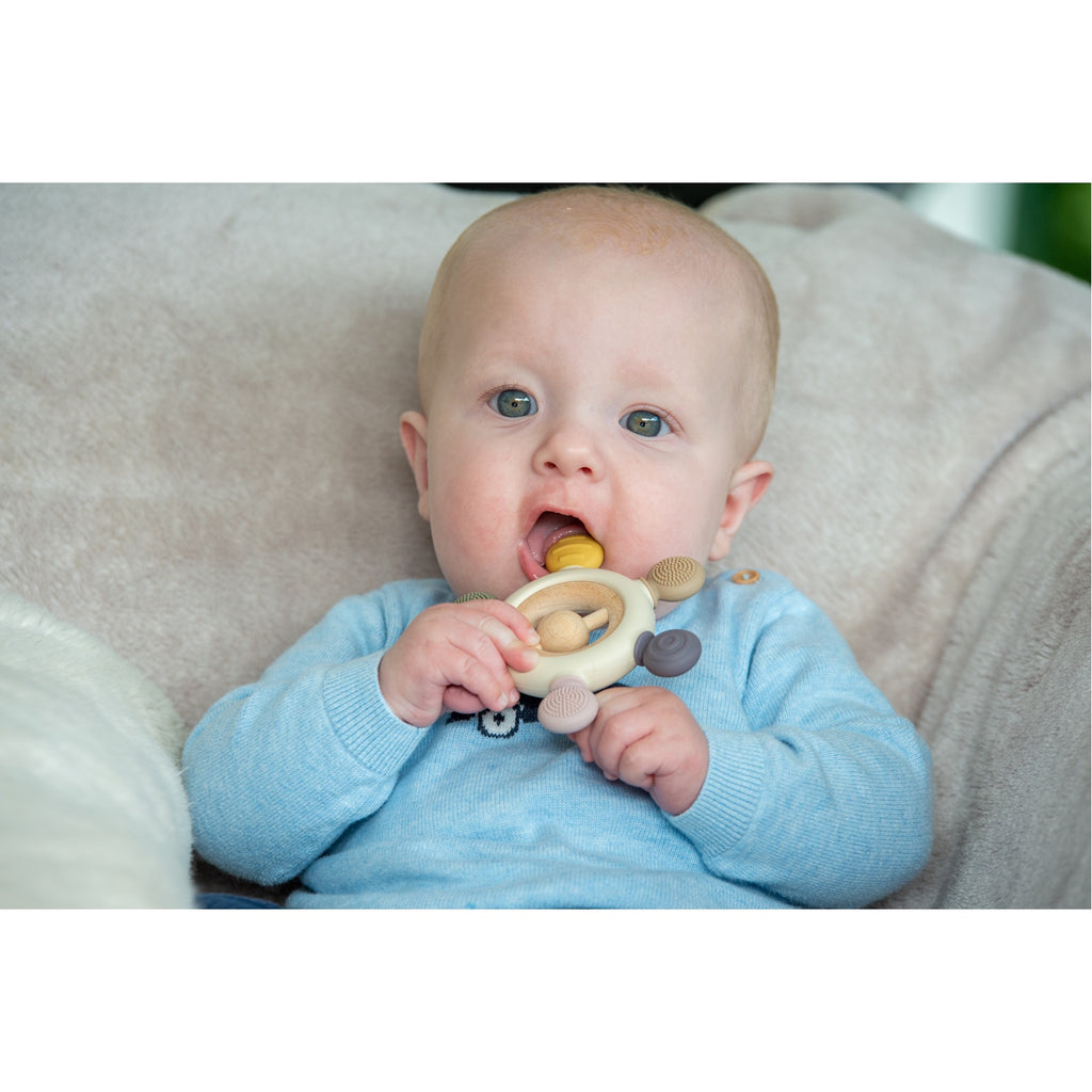 A soft silicone teether with a built-in rattle, designed in earthy tones to soothe and engage babies while promoting sensory development.