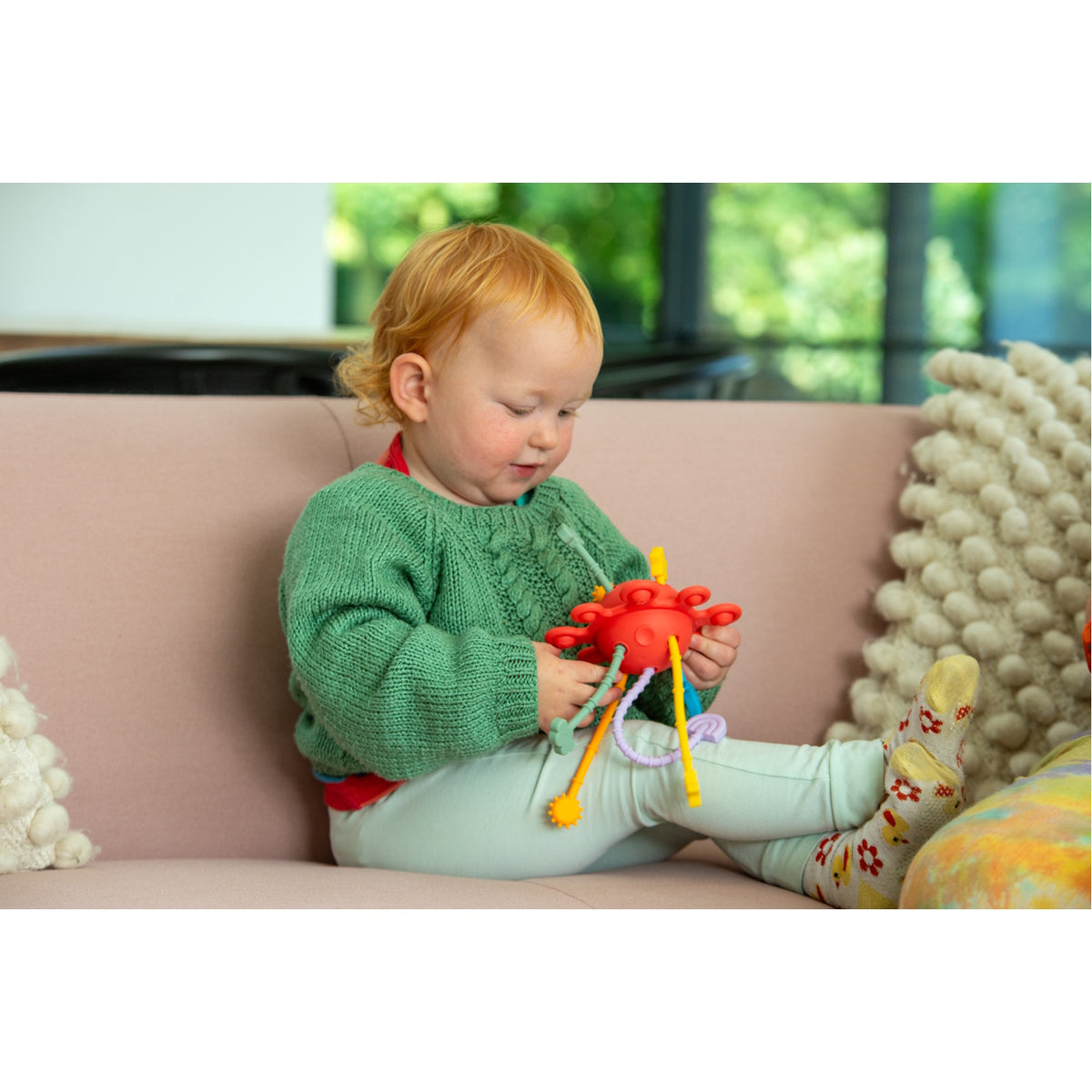 A colorful silicone pull toy with textured zip-like ridges, designed to support sensory development and fine motor skills in young children.