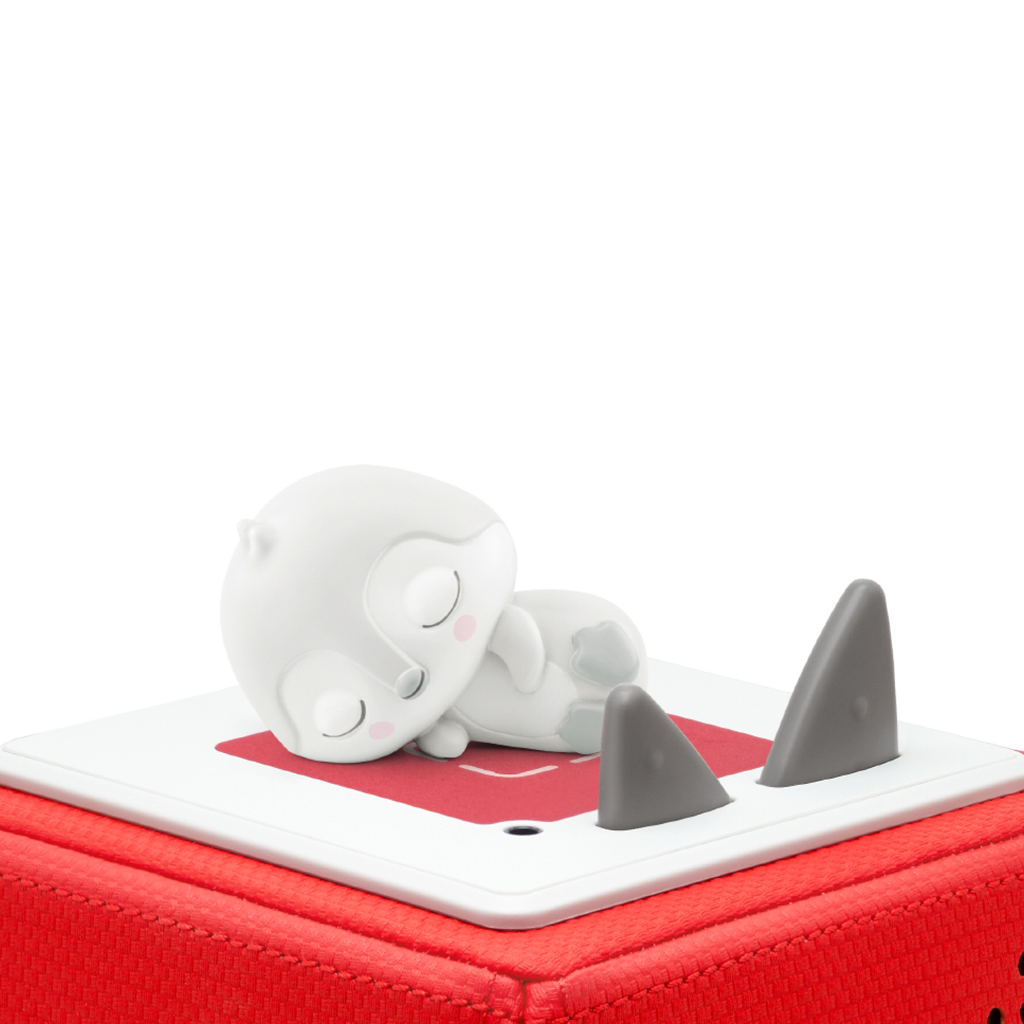 A cute, minimalist ceramic figurine of a sleeping penguin, predominantly white with gray accents and rosy cheeks.