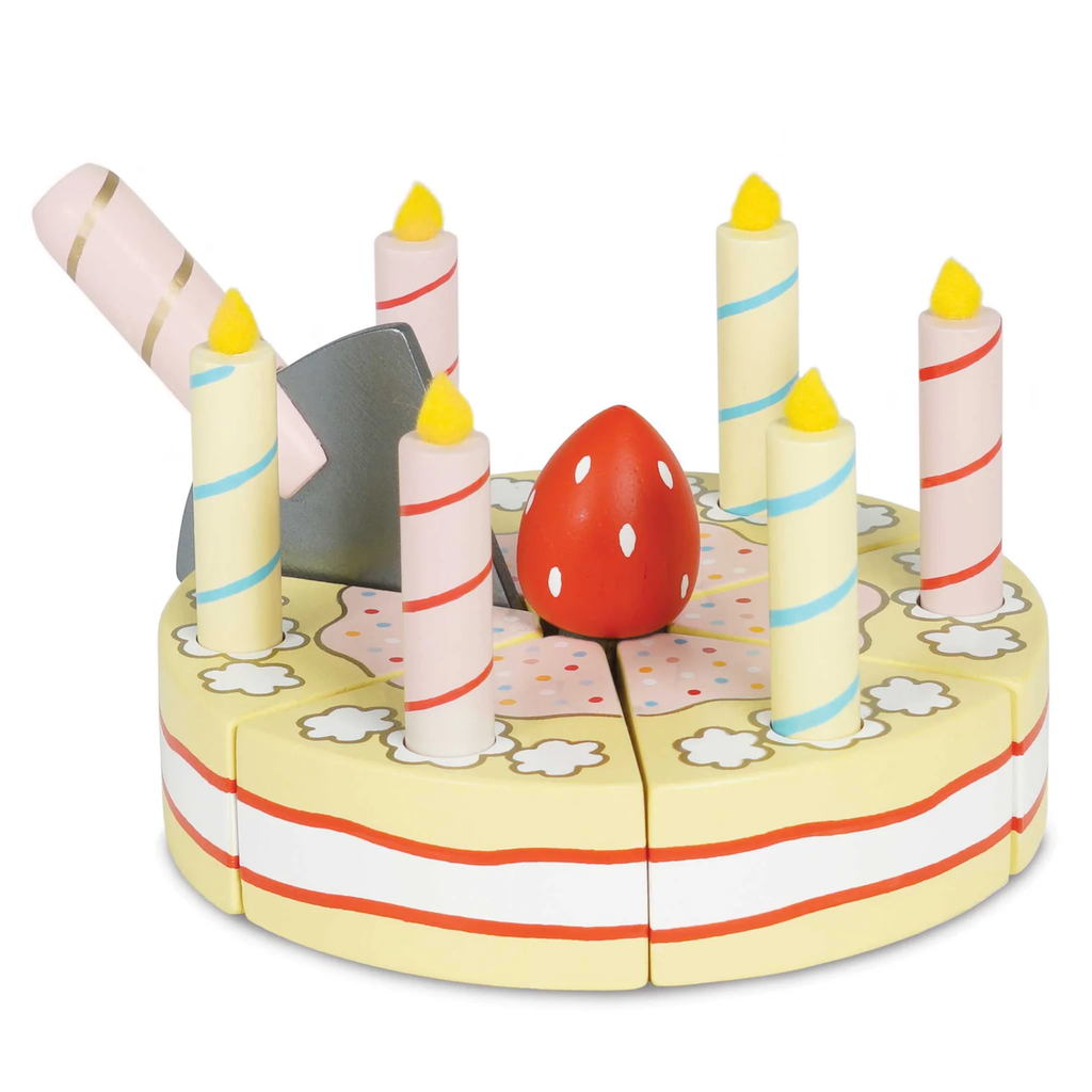 Toy birthday cake with six striped candles, adorned with a red polka-dotted mushroom. A toy cake cutter is placed between the slices. Playful and festive.