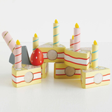 Wooden sliceable toy birthday cake with candles and strawberry.